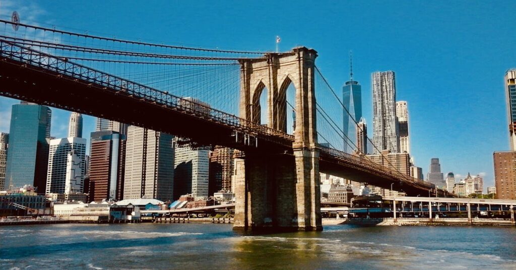 Best Way to Get from Newark Airport to Brooklyn: Factors To Consider 3 Stunning view of the Brooklyn Bridge and New York City skyline under clear blue skies.